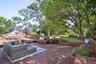 Wooden terrace with view of wooded area and an outdoor hangout area