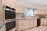 Kitchen featuring stainless steel double oven, cream cabinets, black dishwasher, tasteful backsplash, and recessed lighting