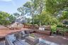 Wooden terrace featuring view of wooded area and an outdoor hangout area