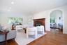 Living room with wood finished floors, recessed lighting, a fireplace, and arched walkways