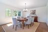 Dining area with a chandelier and dark wood-style flooring