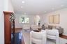 Living room with arched walkways, wood finished floors, and recessed lighting