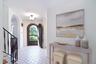 Foyer entrance featuring stairs, arched walkways, and light tile patterned floors