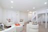 Carpeted living area with recessed lighting and stairway
