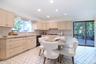 Kitchen featuring light stone countertops, cream cabinets, recessed lighting, and backsplash