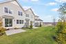 Rear view of house with a yard, central AC unit, and a patio