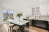 Kitchen featuring sink, a breakfast bar area, dishwasher, a kitchen island, and decorative backsplash