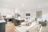 Kitchen featuring a kitchen island, tasteful backsplash, white cabinetry, stainless steel appliances, and light wood-type flooring