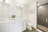 Bathroom with a tile shower, vanity, tile patterned floors, and toilet