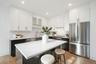 Kitchen featuring stainless steel appliances, a kitchen breakfast bar, white cabinets, and a kitchen island