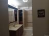 Bathroom featuring a vanity with a light-colored countertop, an integrated sink, and wood-finish cabinetry