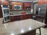 Kitchen featuring rich wood-finish cabinetry, stainless steel double ovens, a built-in microwave, a stainless steel side-by-side refrigerator, and sto
