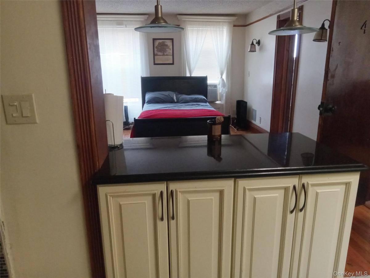 Cream-colored cabinetry with dark hardware and a black countertop