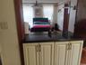 Cream-colored cabinetry with dark hardware and a black countertop