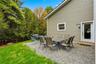 Outdoor patio space featuring a gravel surface, exterior wall with horizontal siding, and a white framed door with a glass panel