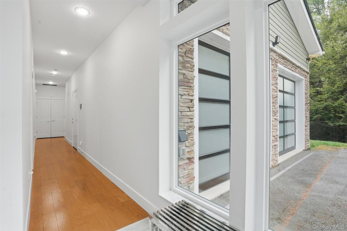 Long hallway with wood-finish flooring and recessed lighting