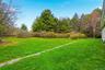 Expansive lawn area featuring a gravel path and mature trees