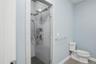 Modern walk-in shower with clear glass enclosure and tiled walls