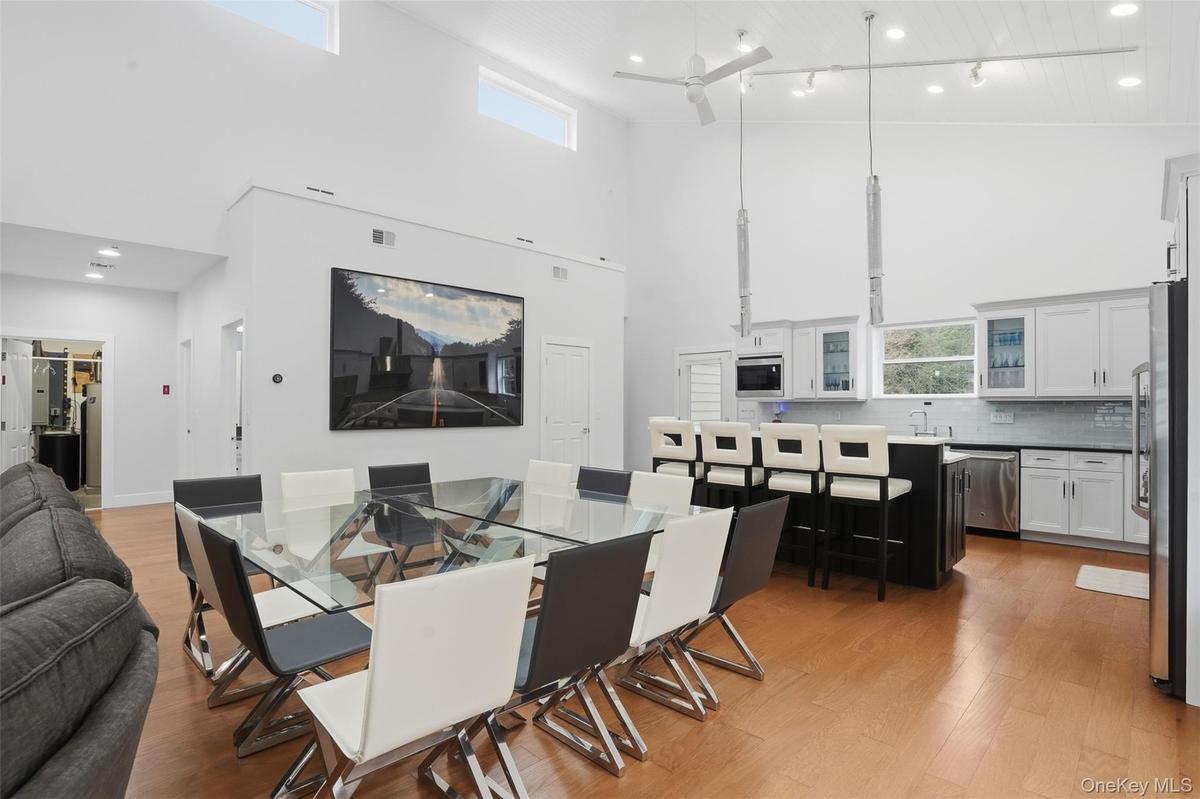 Open-concept living space featuring high vaulted ceilings and light wood-finish flooring