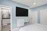 Bedroom featuring light blue walls, white trim, and a ceiling fan