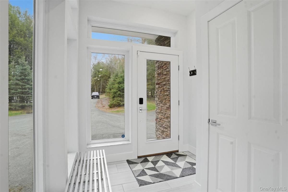 Bright entryway featuring a full-light glass entry door, side windows, transom window, and tiled flooring