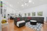 Expansive open-concept living area featuring high vaulted ceilings, recessed lighting, and wood-finish flooring