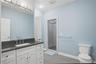 Bathroom featuring a white vanity with a dark stone countertop and an undermount sink
