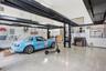 Spacious garage featuring a four-post car lift, polished concrete flooring, built-in shelving, and a dedicated workspace