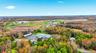 Expansive property featuring a circuit track, multiple buildings with green roofs, and a large paved parking area