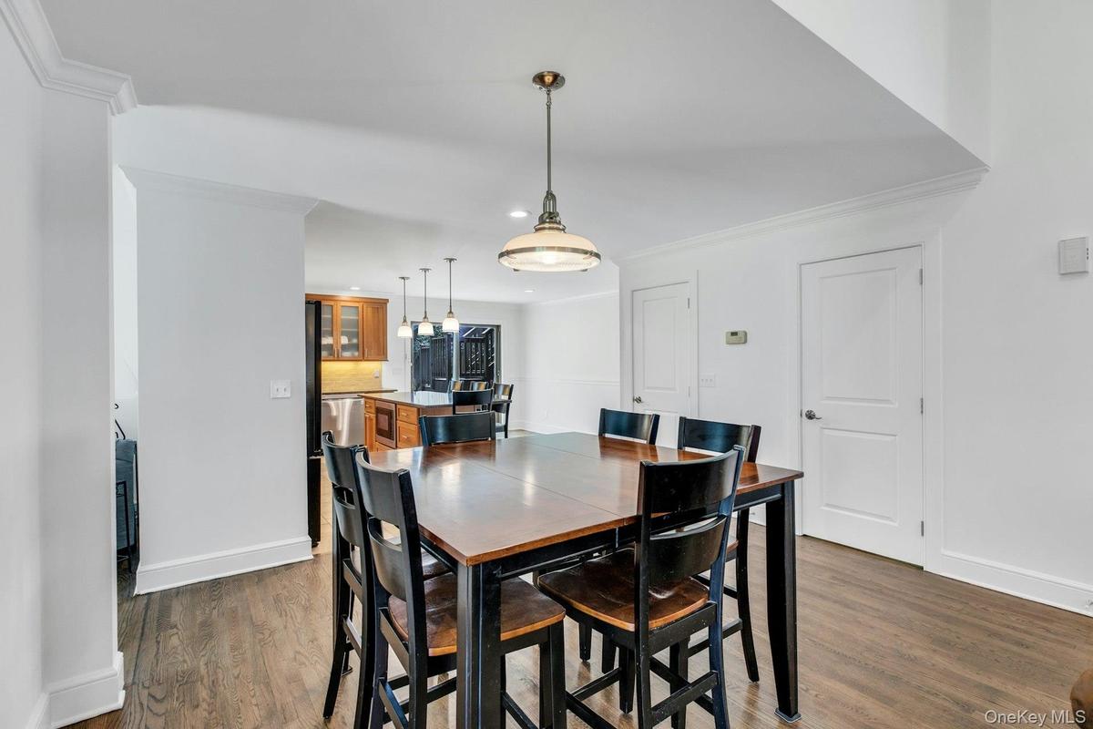 Dining area featuring wood-finish flooring and a central pendant light fixture