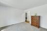 Wall-to-wall carpeting in a neutral tone and white wall paint throughout