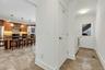 Bright hallway with tile flooring, crown molding, and a white paneled door