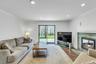 Living space featuring wood-finish flooring, a stacked stone fireplace with a white mantel, and recessed lighting
