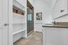 Ensuite Bathroom featuring a frameless glass shower enclosure, a single vanity with a solid surface countertop, an undermount sink, and a wall-mounted