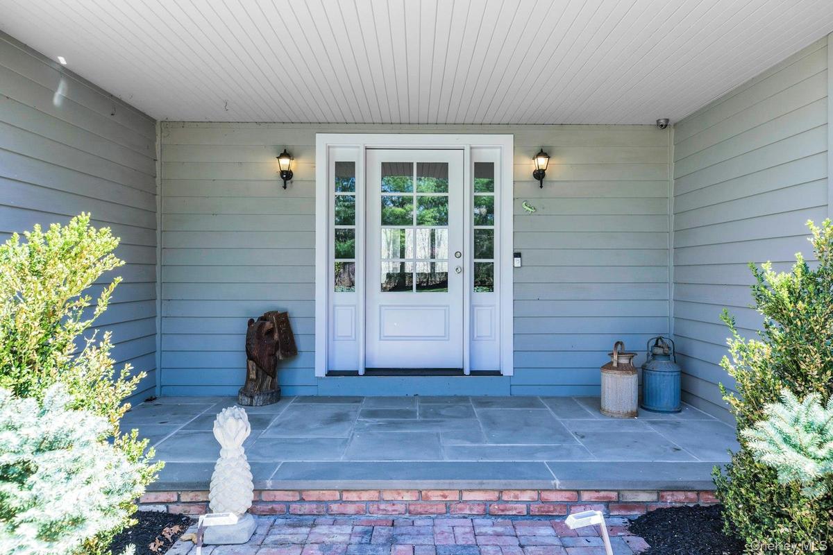 Inviting covered front entry featuring a double glass-panel door, sidelights, and overhead lighting