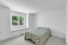 Bright room featuring a large window with a built-in sill and light-colored carpeting