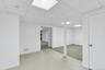 Partially Finished lower level featuring a drop ceiling with recessed lighting, painted support column, white panel door, and light-toned flooring