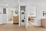 Laundry area featuring electric panel, stacked washer and clothes dryer, light wood-type flooring, and recessed lighting