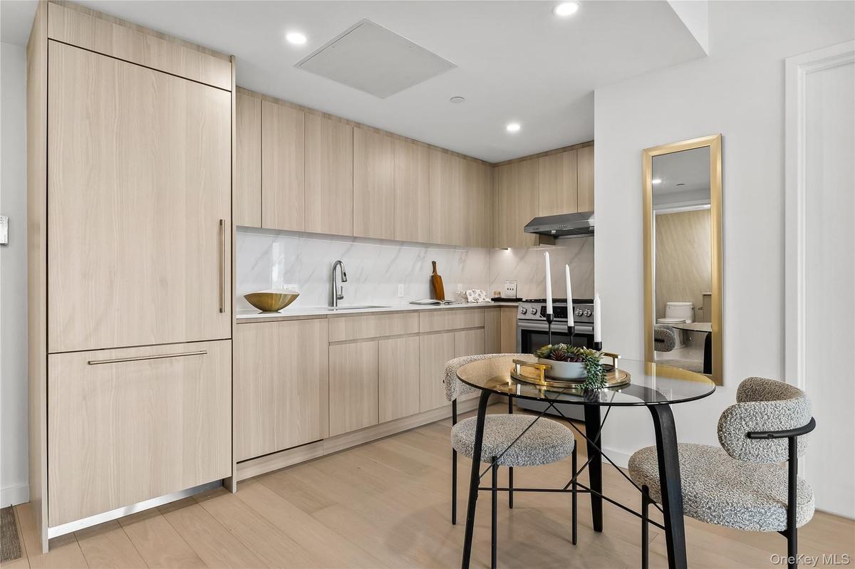 Kitchen with modern cabinets, light brown cabinets, light wood-style floors, stainless steel range, and recessed lighting