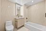 Full bath featuring vanity, tile walls, washtub / shower combination, and recessed lighting
