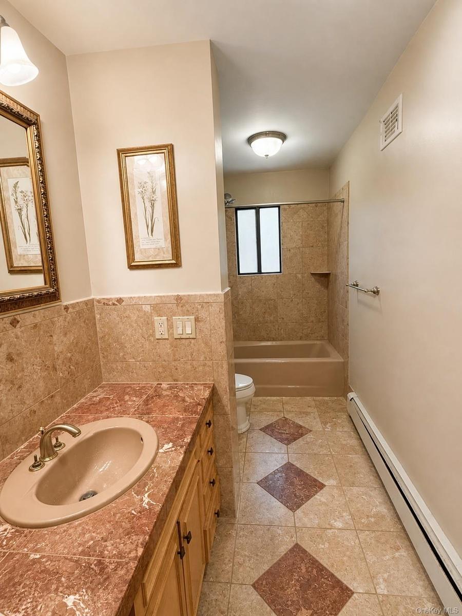 Bathroom vanity with a built-in sink, gold-toned faucet, and cabinetry
