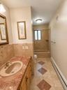 Bathroom vanity with a built-in sink, gold-toned faucet, and cabinetry