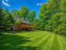 Expansive rear yard featuring a large wooden deck with staircase access