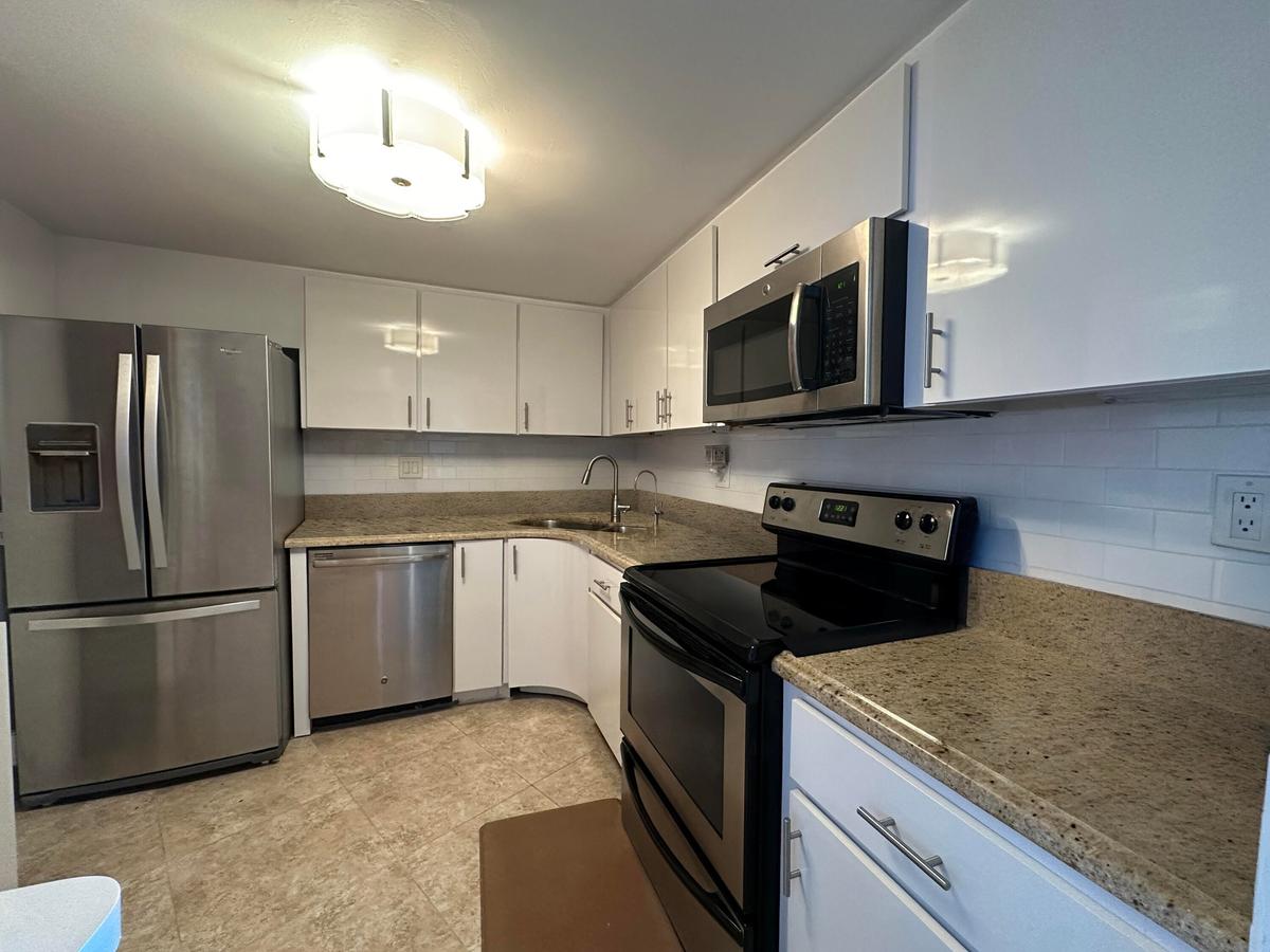 Bright white cabinetry and stainless appliances create a clean, coastal feel, effortless and welcoming