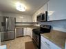 Bright white cabinetry and stainless appliances create a clean, coastal feel, effortless and welcoming