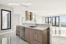 Kitchen with light stone counters, open shelves, modern cabinets, stainless steel dishwasher, and open floor plan