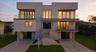Contemporary house featuring a balcony, stairway, stucco siding, and concrete driveway