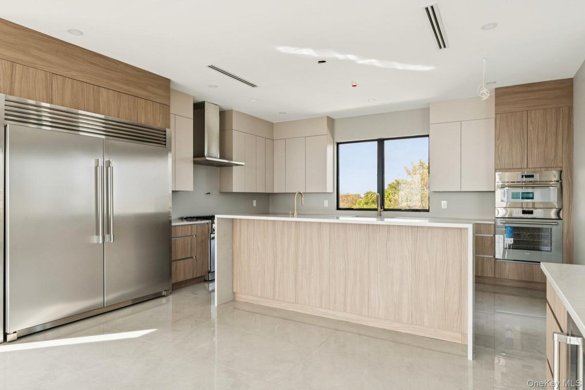 Kitchen featuring appliances with stainless steel finishes, a center island, and modern cabinets