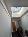Doorway featuring baseboards and a raised ceiling