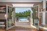 View from living room to expansive deck and pool complex beyond.